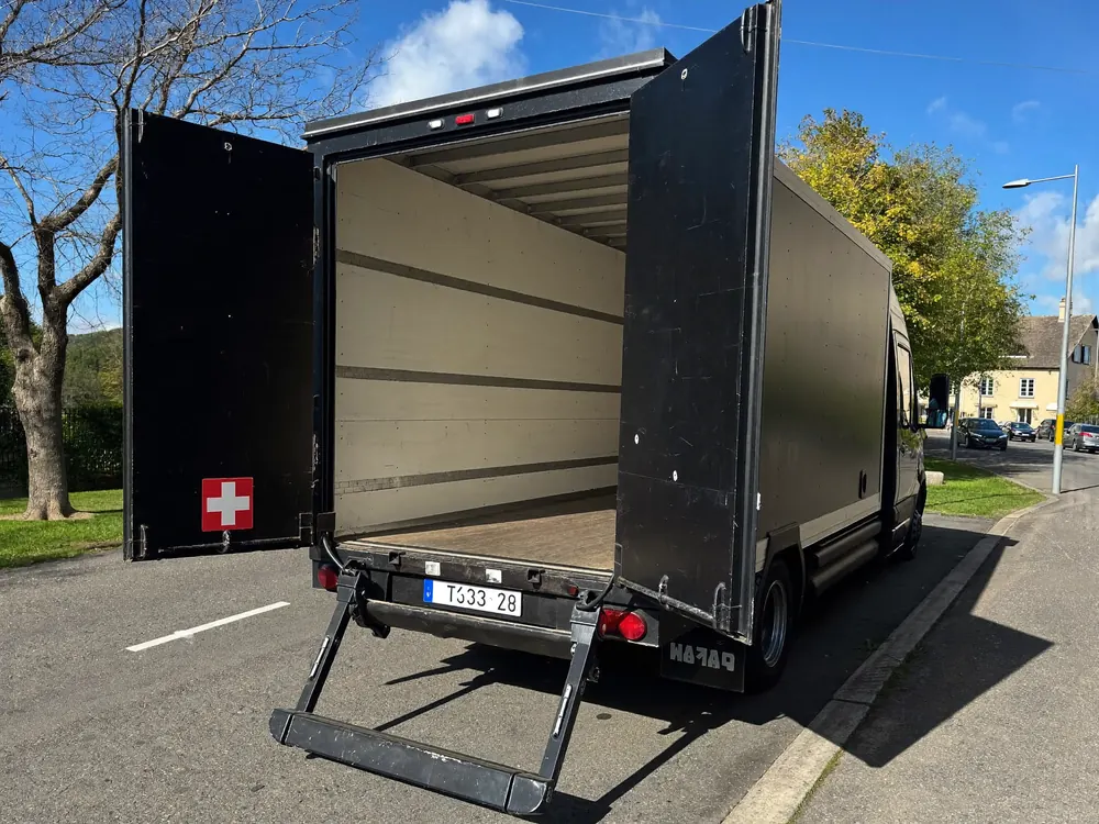 Camion noir 25 m³, hayon abaissé et portes ouvertes